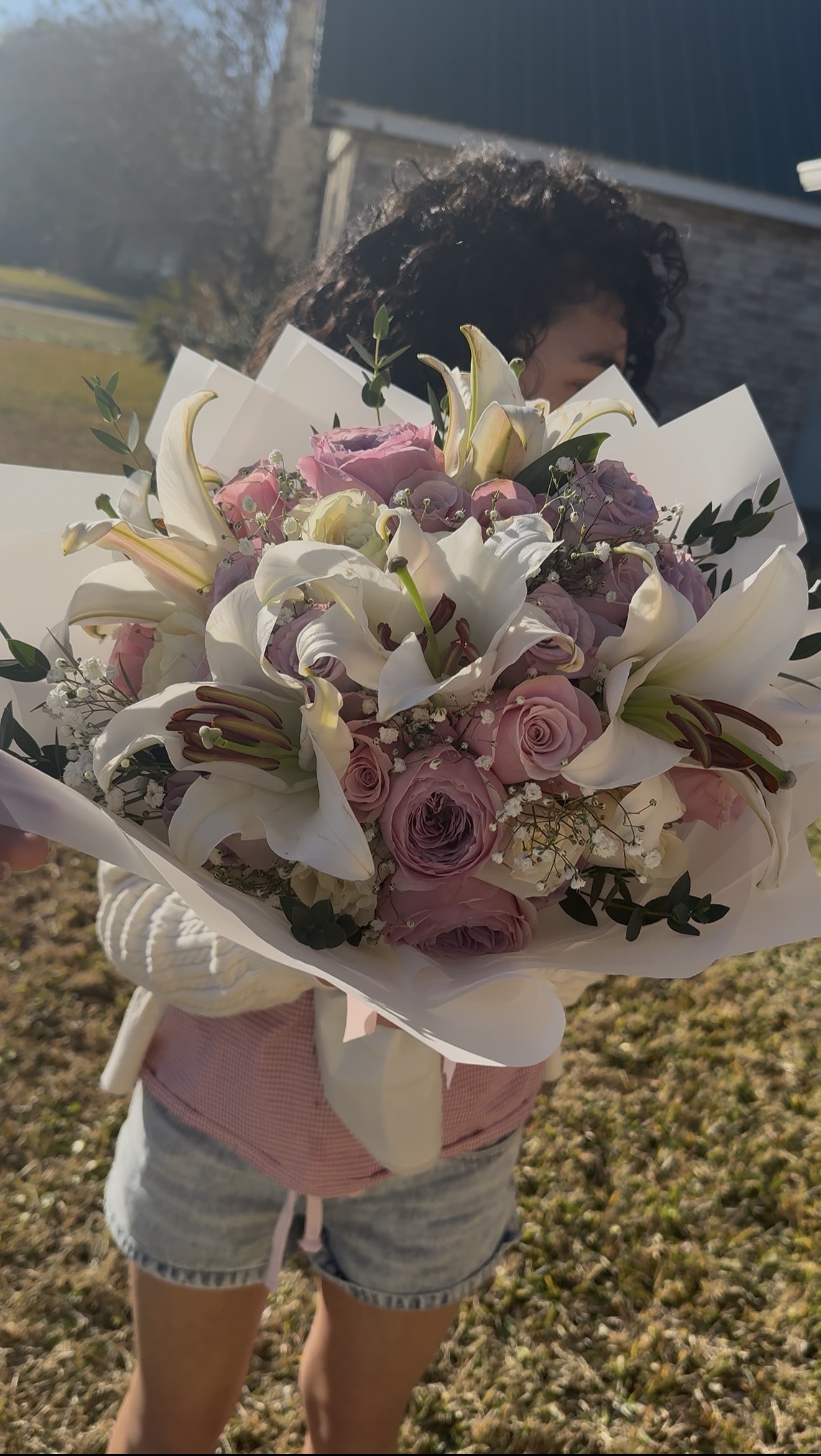 Ana holding a beautiful bouquet of white lilies and lavender roses